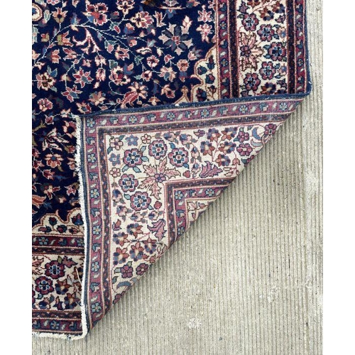 178 - A Persian rug with geometric floral design on a blue ground within a multi border, 130 by 210cms.