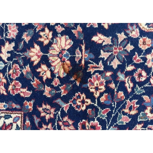 178 - A Persian rug with geometric floral design on a blue ground within a multi border, 130 by 210cms.