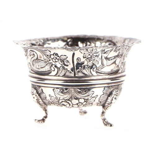 506 - An early 20th century George III style silver bowl with repousse decoration depicting dogs, swans an... 