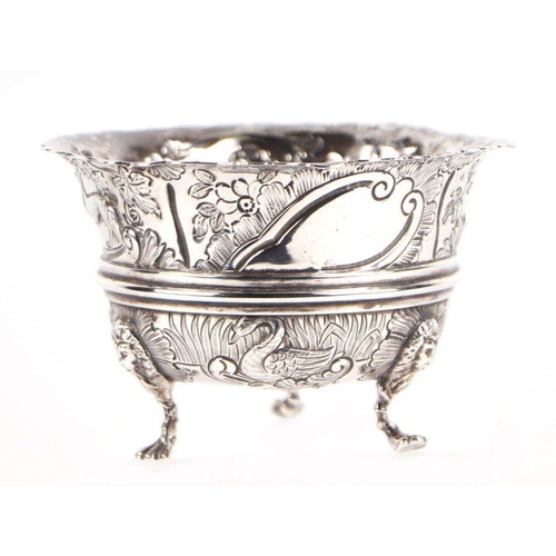 506 - An early 20th century George III style silver bowl with repousse decoration depicting dogs, swans an... 