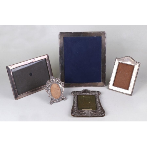 509 - A George V silver rectangular strut photo frame, Birmingham 1918, 18 by 24cms; together with four si... 