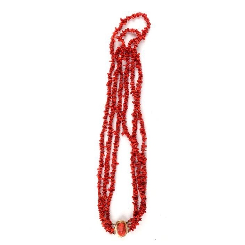 518 - A Victorian coral three-strand necklace with yellow coloured metal clasp and coral cameo in the form... 