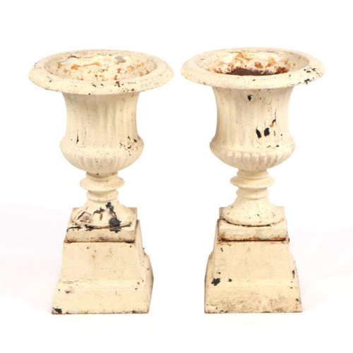 9 - A pair of painted cast iron Campana urns on stands, 51cms high (2).