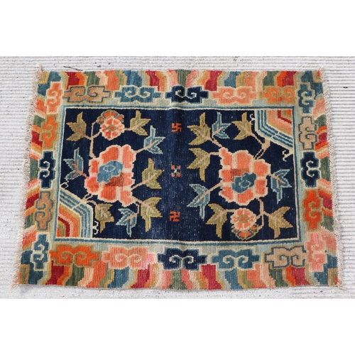 174 - A Tibetan saddle blanket; together with three Tibetan hand knotted meditation rugs, the largest 88 b... 