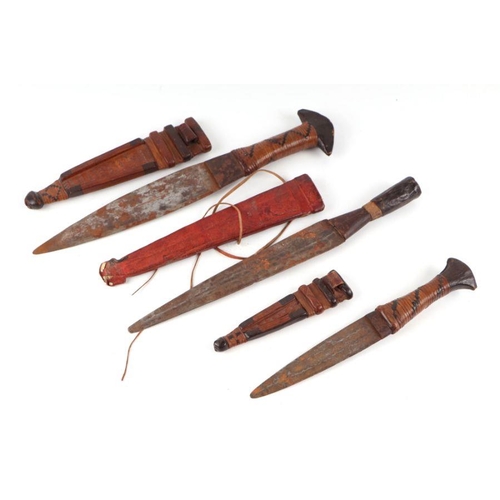 109 - A group of ethnic daggers and scabbards, the largest 37cms long.