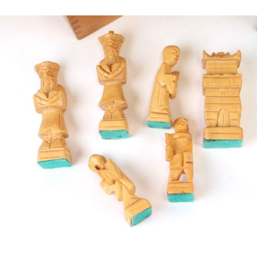 115 - An Oriental carved wooden chess set.