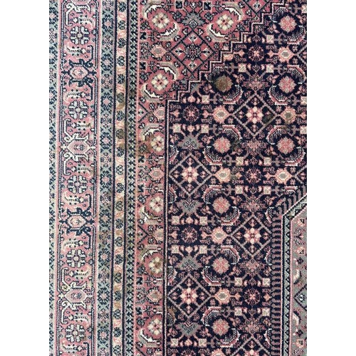 133 - A Persian Kashan rug with geometric design on a pink ground, 170 by 237cms.