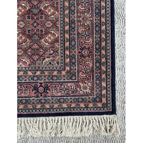 133 - A Persian Kashan rug with geometric design on a pink ground, 170 by 237cms.