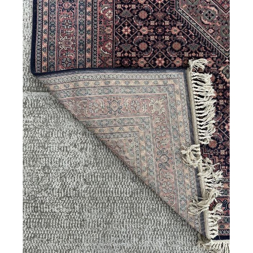 133 - A Persian Kashan rug with geometric design on a pink ground, 170 by 237cms.