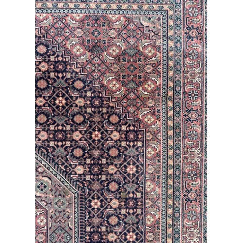 133 - A Persian Kashan rug with geometric design on a pink ground, 170 by 237cms.