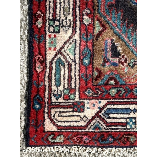 140 - A Persian Hamadan runner on a red ground, 280 by 80cms (333).