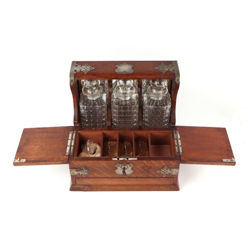 342 - A late 19th century oak three bottle Tantalus, the front section opening to reveal compartments cont... 