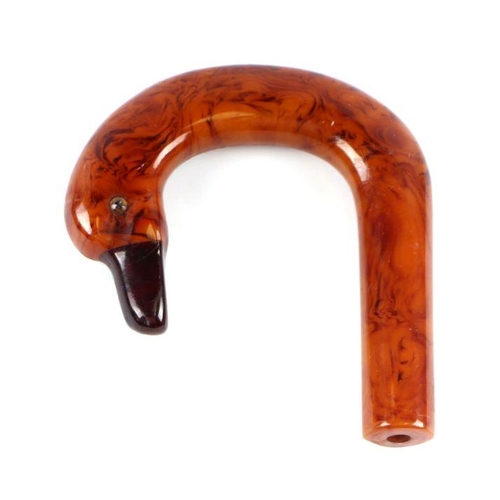 351 - An early plastic amber like walking stick handle in the form of a duck with a cherry amber Bakelite ... 