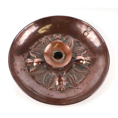 354 - An Arts and Crafts Newlyn style copper candlestick decorated with bats, 22cms diameter.