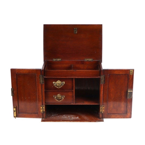 375 - An early 20th century oak smoker's cabinet with lift-up top and two panelled doors enclosing a fitte... 