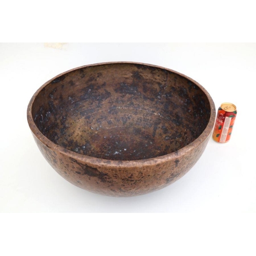 389 - A large hand beaten brass bowl, 55cms diameter.