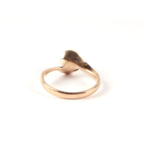 542 - A 9ct gold and solitaire pearl ring in an open cross-over hands setting, approx UK size 'I', 2g.