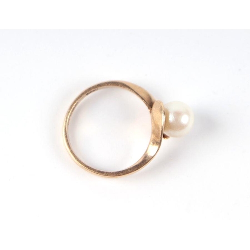 542 - A 9ct gold and solitaire pearl ring in an open cross-over hands setting, approx UK size 'I', 2g.