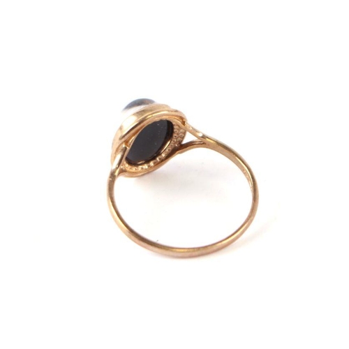 563 - A 9ct gold dress ring set with a smoky quartz cabochon, approx UK size 'M', 1.6g.