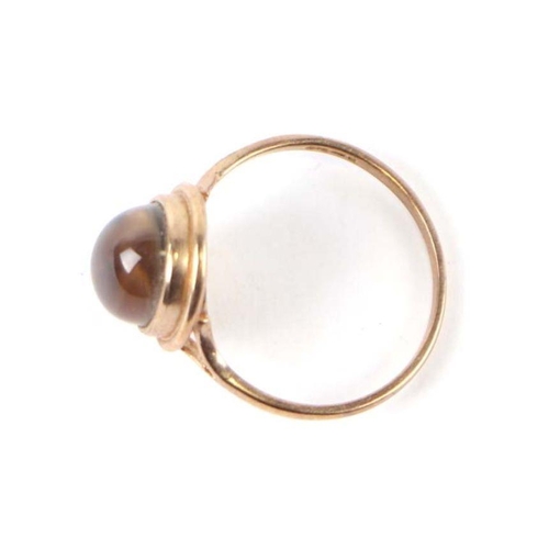 563 - A 9ct gold dress ring set with a smoky quartz cabochon, approx UK size 'M', 1.6g.