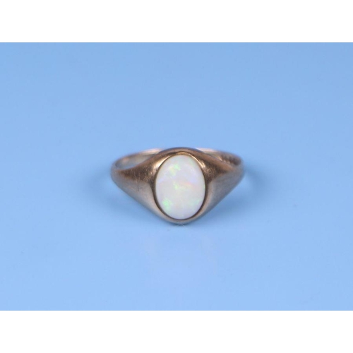 565 - A 9ct gold ring set with an oval opal cabochon, approx UK size 'I', 1.2g.