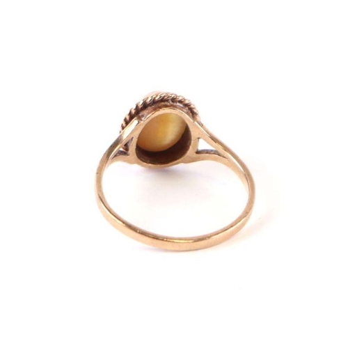 567 - A 9ct gold dress ring set with an oval tiger's eye cabochon, approx UK size 'O', 2.3g.