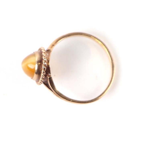 567 - A 9ct gold dress ring set with an oval tiger's eye cabochon, approx UK size 'O', 2.3g.