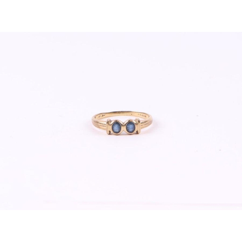 571 - A 9ct gold ring set with two pale sapphires, approx UK size 'O', 1.6g.