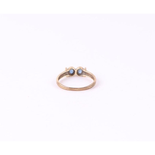 571 - A 9ct gold ring set with two pale sapphires, approx UK size 'O', 1.6g.