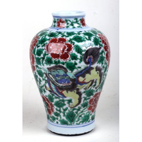 579 - A Chinese famille verte baluster vase decorated with shishi and prunus, 19cms high