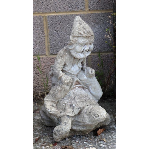 6 - A reconstituted stone garden statue depicting a gnome riding a tortoise, 51cms high.