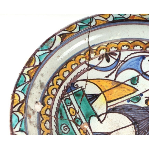 633 - An Iznik pattern footed bowl decorated with a stylised ship (a/f), 29.5cms diameter.