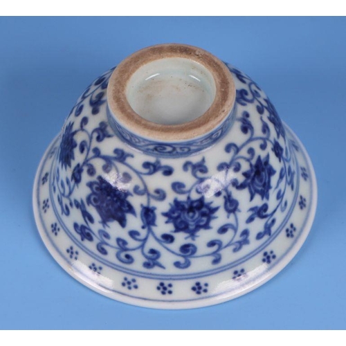 643 - A Chinese blue & white footed bowl decorated with scrolling flowering foliage, 9.5cms diameter.