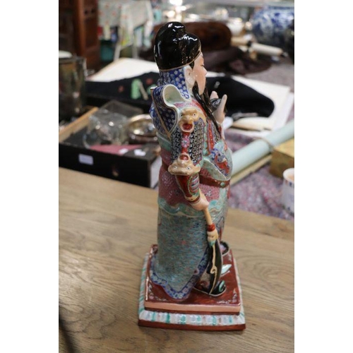 673 - A Chinese figure of Guan Gong with impressed seal mark to the underside, 44cms high.Condition Report... 