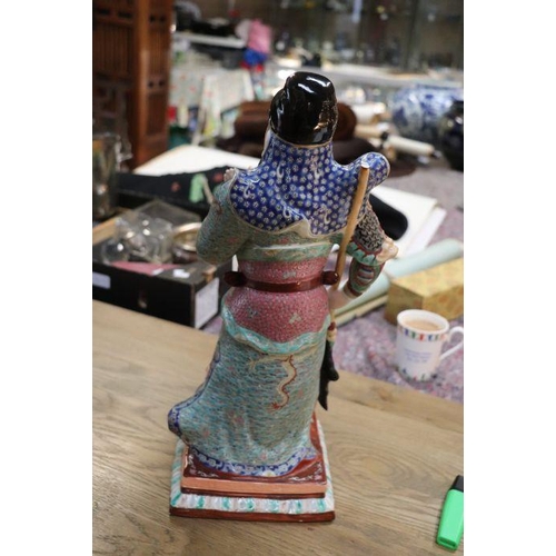 673 - A Chinese figure of Guan Gong with impressed seal mark to the underside, 44cms high.Condition Report... 