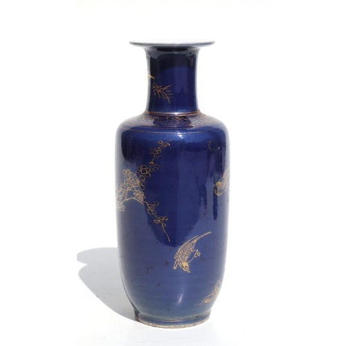 674 - A Chinese rouleau vase with gilt decoration on a blue ground, on a hardwood stand, 20cms high.