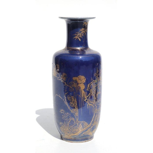 674 - A Chinese rouleau vase with gilt decoration on a blue ground, on a hardwood stand, 20cms high.