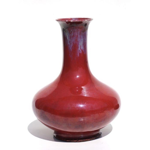 675 - A Chinese flambe vase on a pierced hardwood stand, 29cms high.