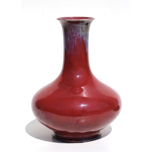 675 - A Chinese flambe vase on a pierced hardwood stand, 29cms high.