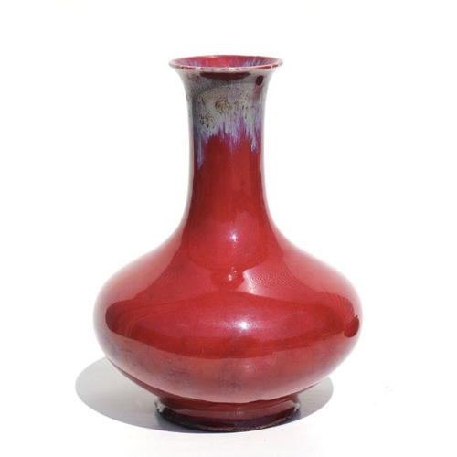 675 - A Chinese flambe vase on a pierced hardwood stand, 29cms high.