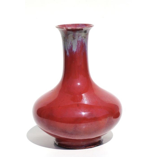 675 - A Chinese flambe vase on a pierced hardwood stand, 29cms high.