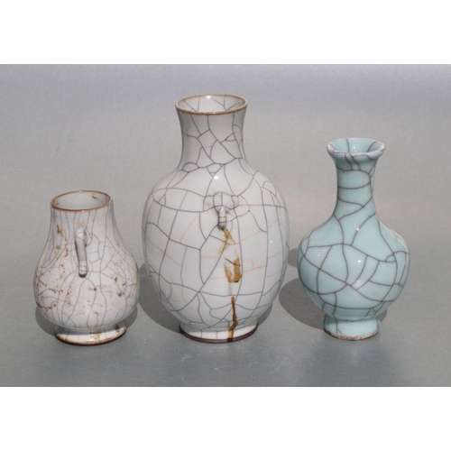 679 - A Chinese pale celadon crackle ware glaze baluster vase on a hardwood stand, 16cms high; together wi... 