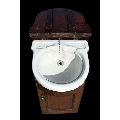 738 - A late 19th century mahogany vanity unit with lift-up top enclosing a ceramic sink and cupboard bene... 