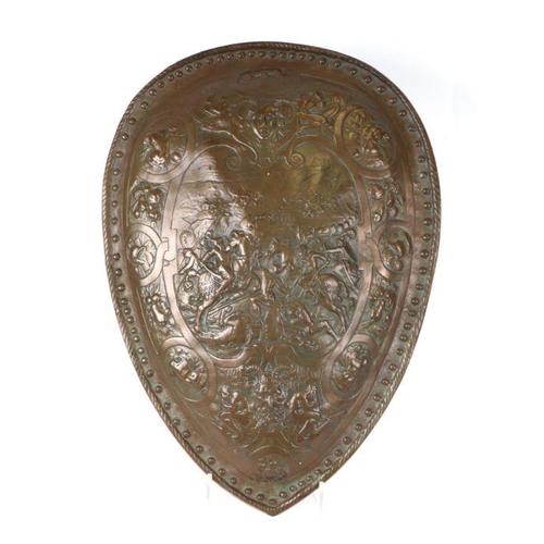 78 - A bronzed composite shield decorated with warriors on horseback and mythical beasts, 43 by 59cms.