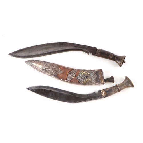 80 - A horn handled kukri in a wooden scabbard with white metal overlay decoration depicting an armorial ... 