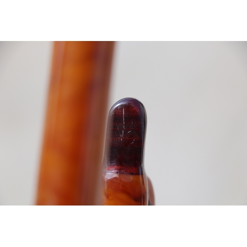 351 - An early plastic amber like walking stick handle in the form of a duck with a cherry amber Bakelite ... 