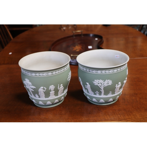 277 - A pair of Wedgwood Jasperware planters decorated with classical figures, 18cms high (2).