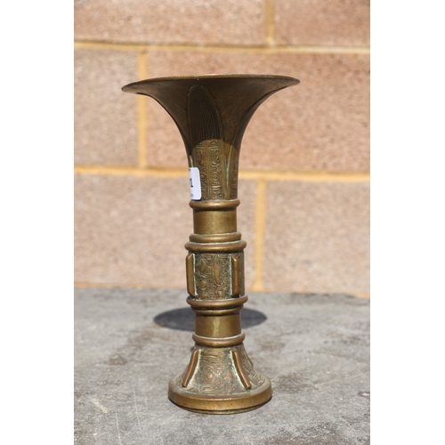 691 - A Chinese bronze / brass Gu type vase of archaic form, 21cms high.