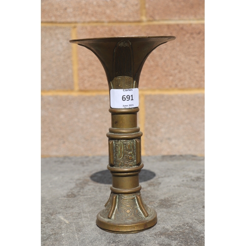 691 - A Chinese bronze / brass Gu type vase of archaic form, 21cms high.