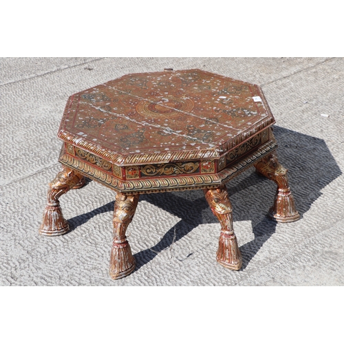 774 - A Kashmiri low prayer table, the octagonal top on eight hoof support legs, 67cms wide.